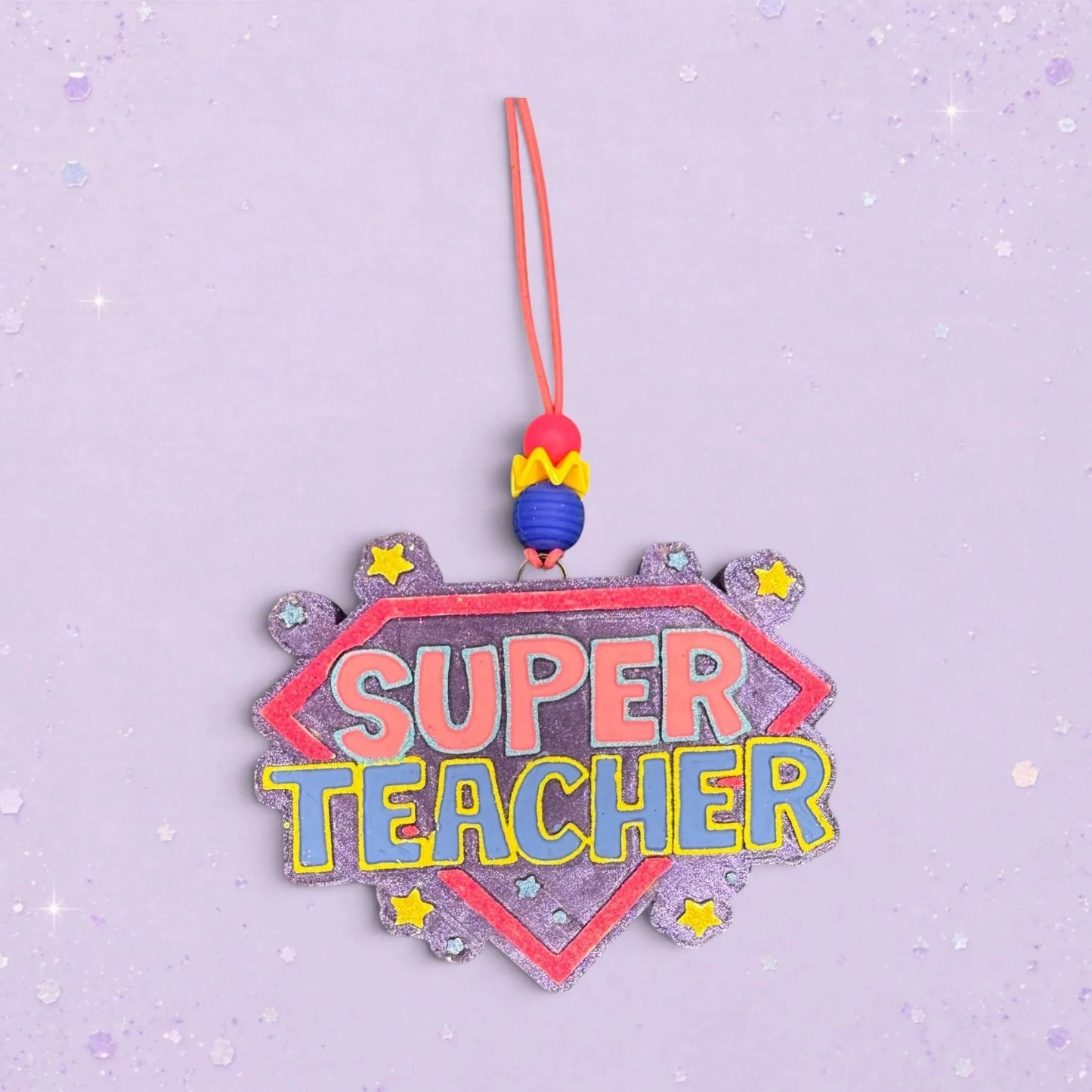 BeFreshie Super Teacher freshie ornament with pink and blue lettering on a purple glitter shield, adorned with yellow stars.