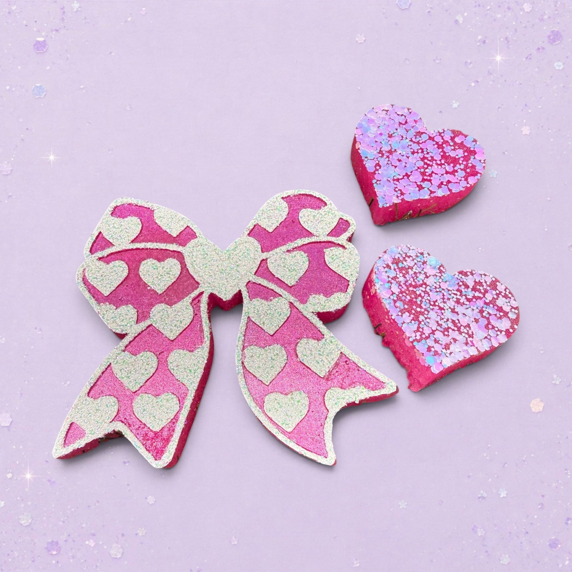 BeFreshie pink bow freshie with white glitter hearts and two matching heart-shaped freshies with pink and purple glitter.