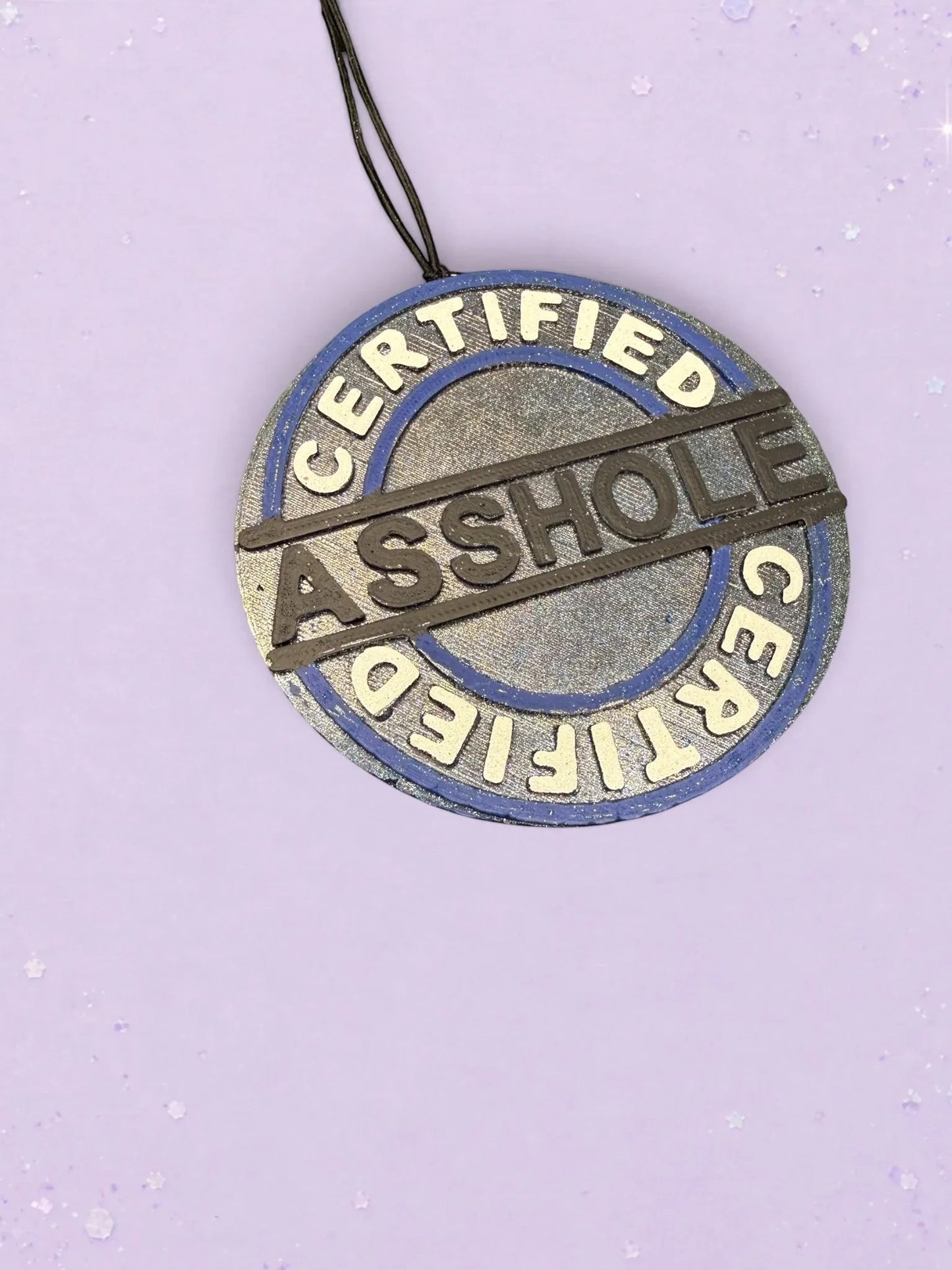 BeFreshie Certified Asshole car air freshener with a blue and silver circular design on a light purple background.