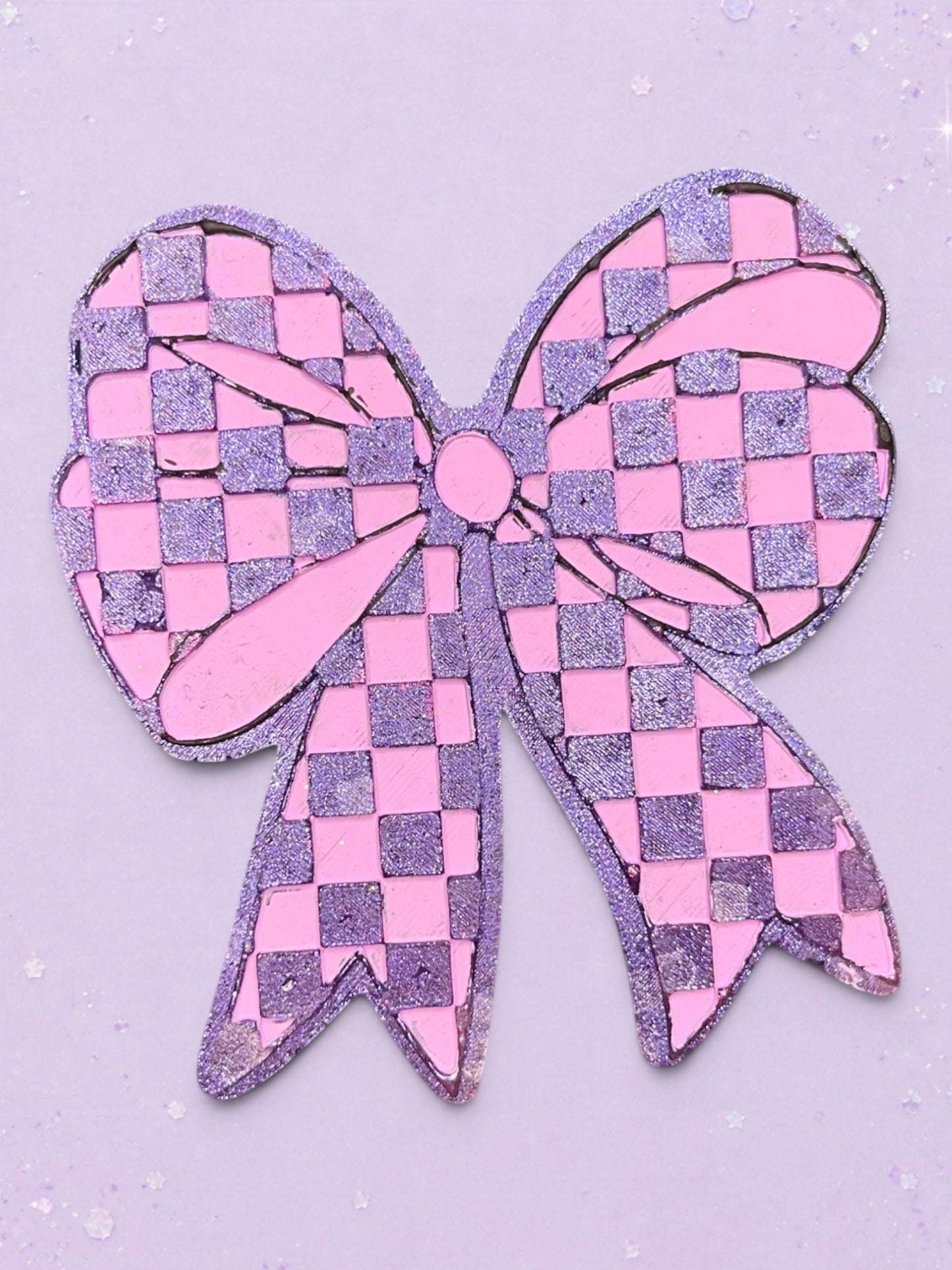 BeFreshie checkered bow car freshie in glittery pink and purple on a matching pastel background.