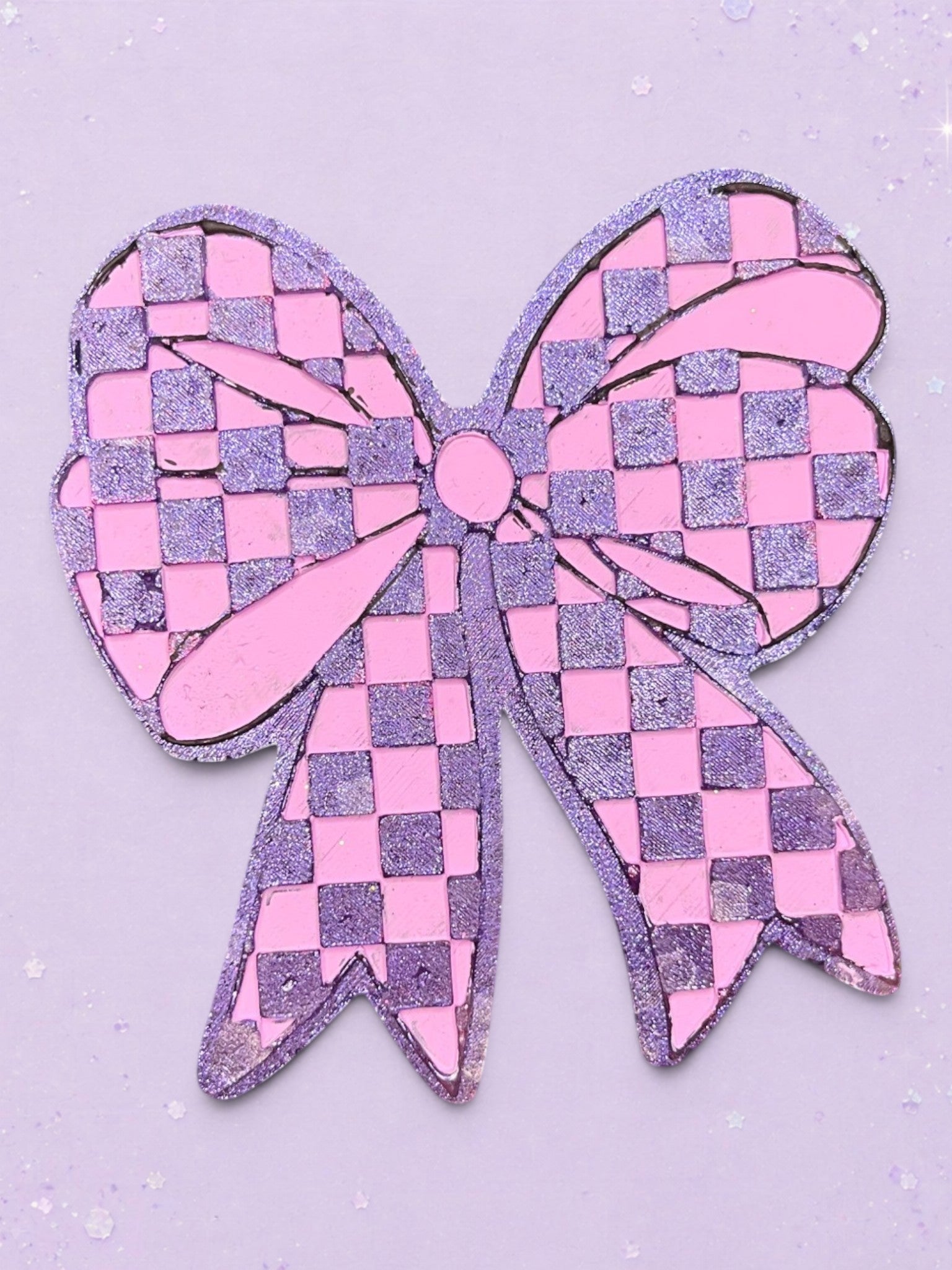 BeFreshie checkered bow car freshie in glittery pink and purple on a matching pastel background.