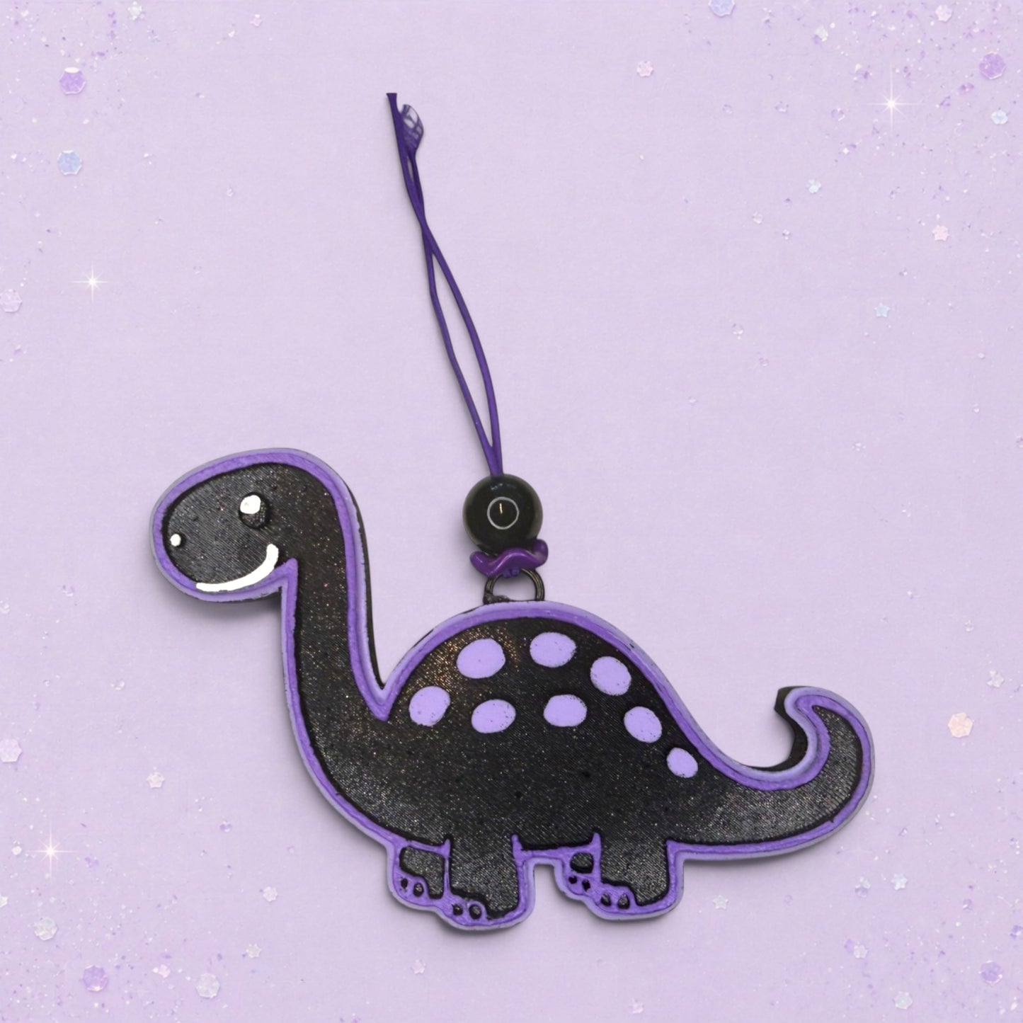 BeFreshie black dinosaur freshie with purple trim and polka dots, featuring a hanging loop and string.