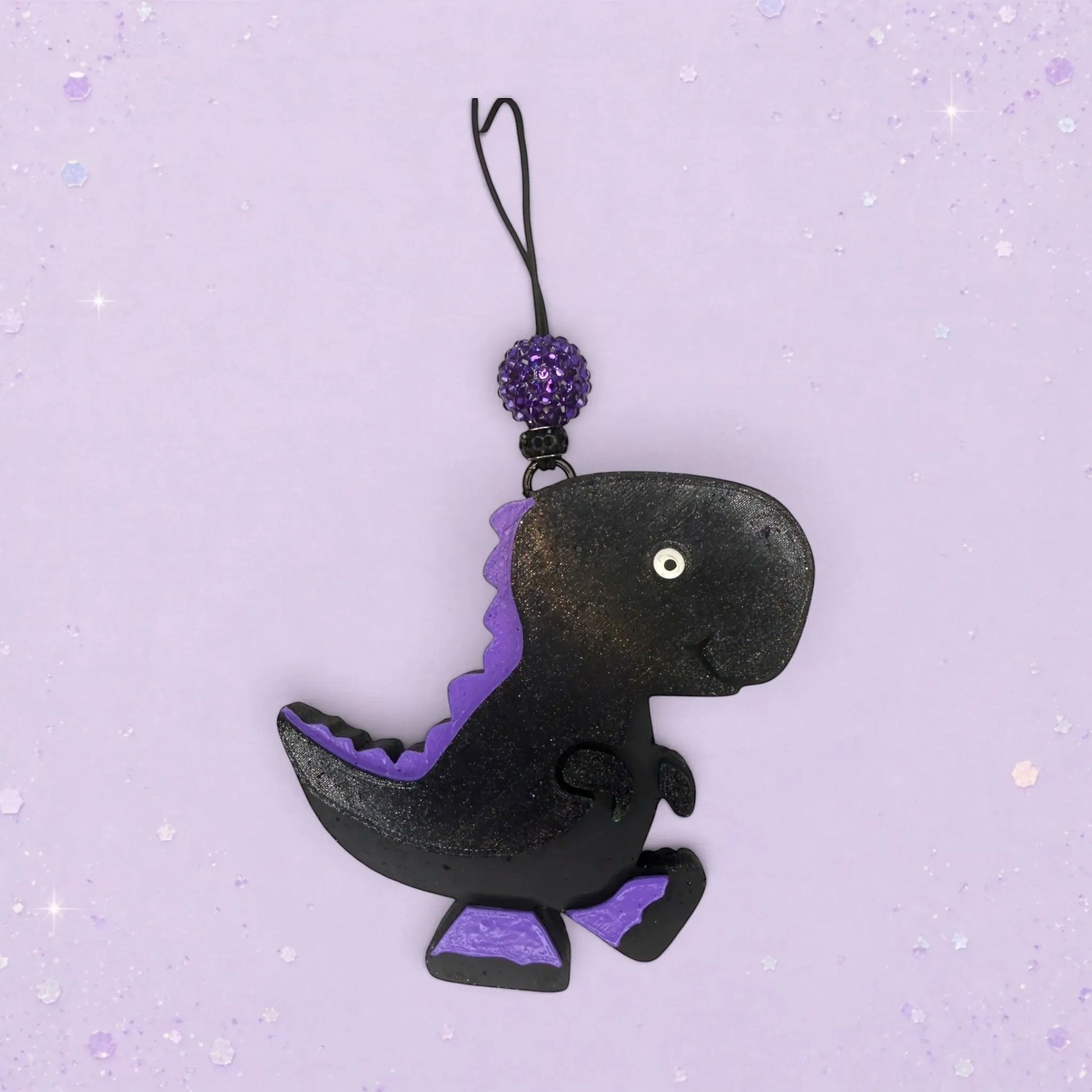 BeFreshie black dinosaur freshie with purple accents and a sparkly purple bead on a hanging loop.