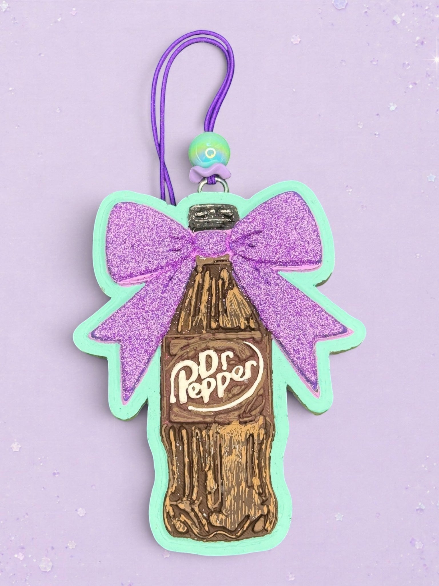 BeFreshie Dr Pepper bottle car freshie featuring a glittery purple bow and mint green border on a purple background.