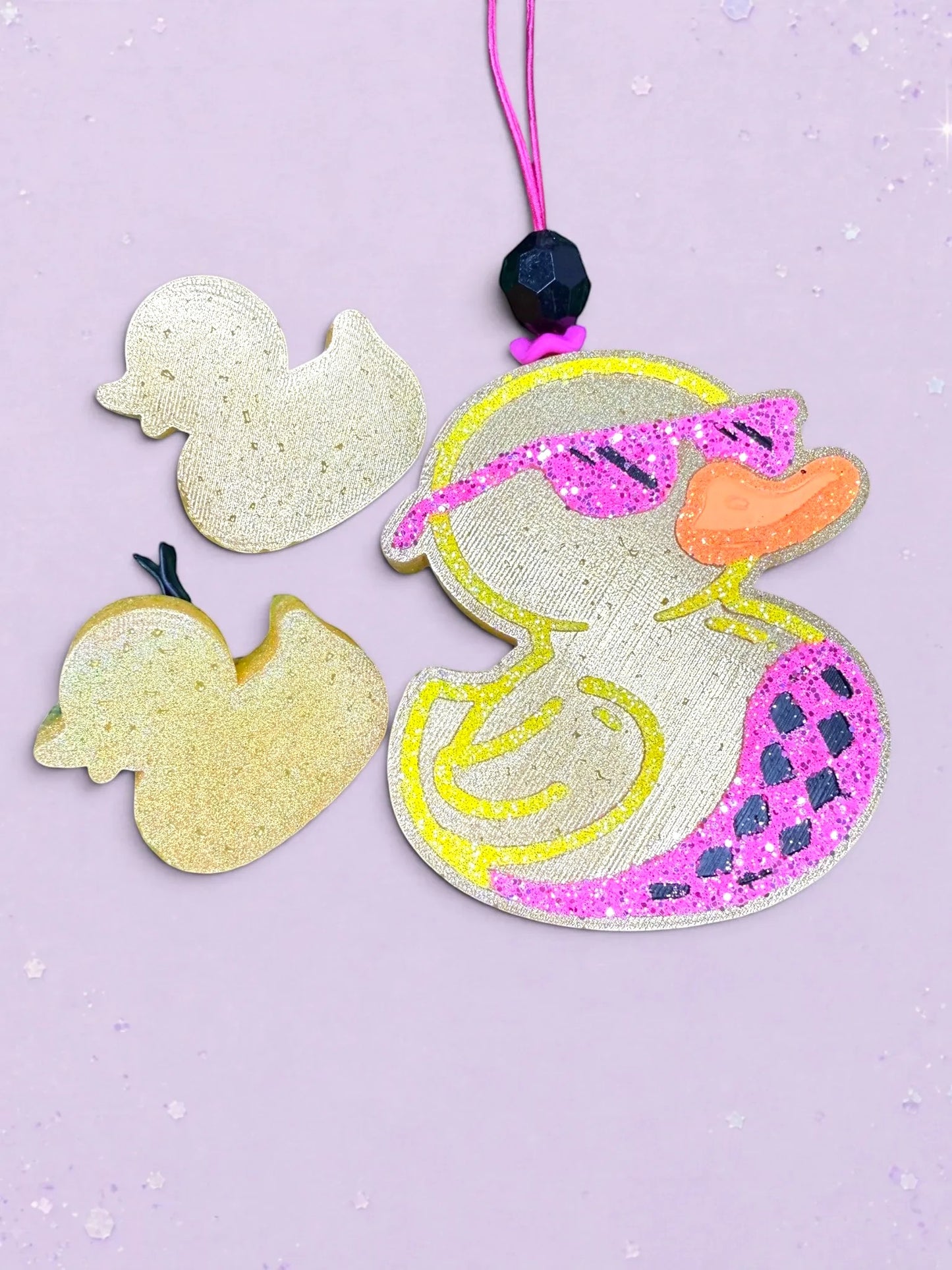 BeFreshie duck car air freshener with pink glitter sunglasses and patterned wing on a light purple background