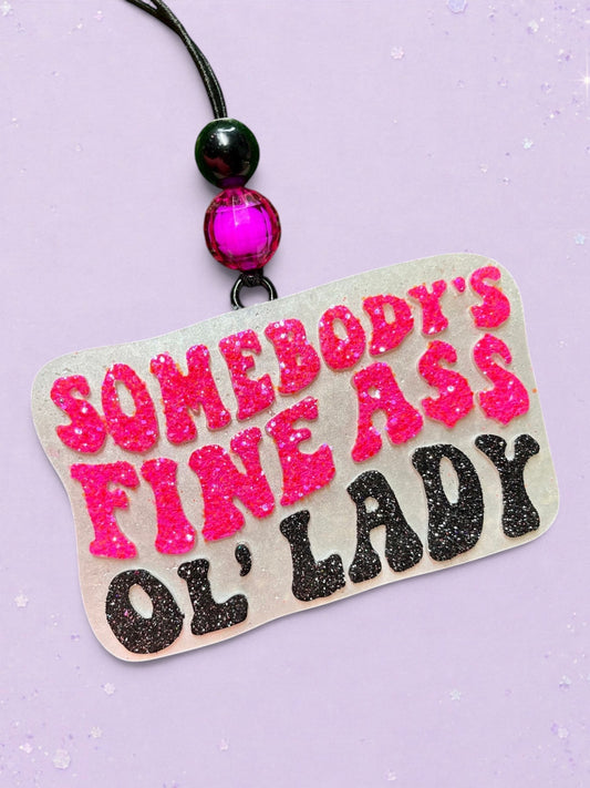 BeFreshie car air freshener with pink and black glitter text reading Somebodys Fine Ass Ol Lady on a light purple background
