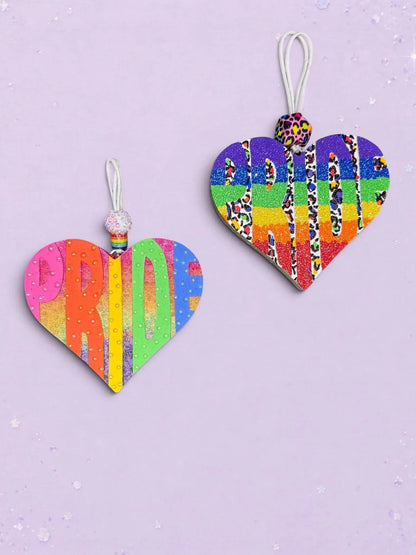 Two BeFreshie heart-shaped PRIDE car air fresheners featuring vibrant rainbow stripes, glitter, and leopard print accents.