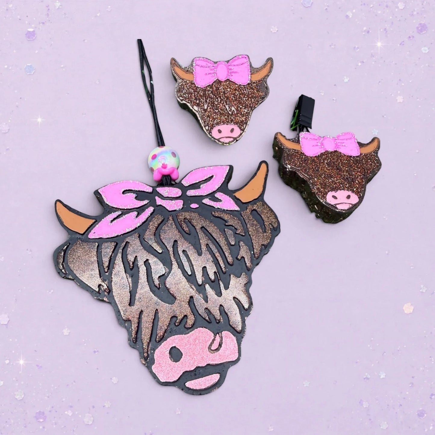 BeFreshie Highland cow head freshie with pink glitter bow and pink nose. Sparkly brown and black fur.