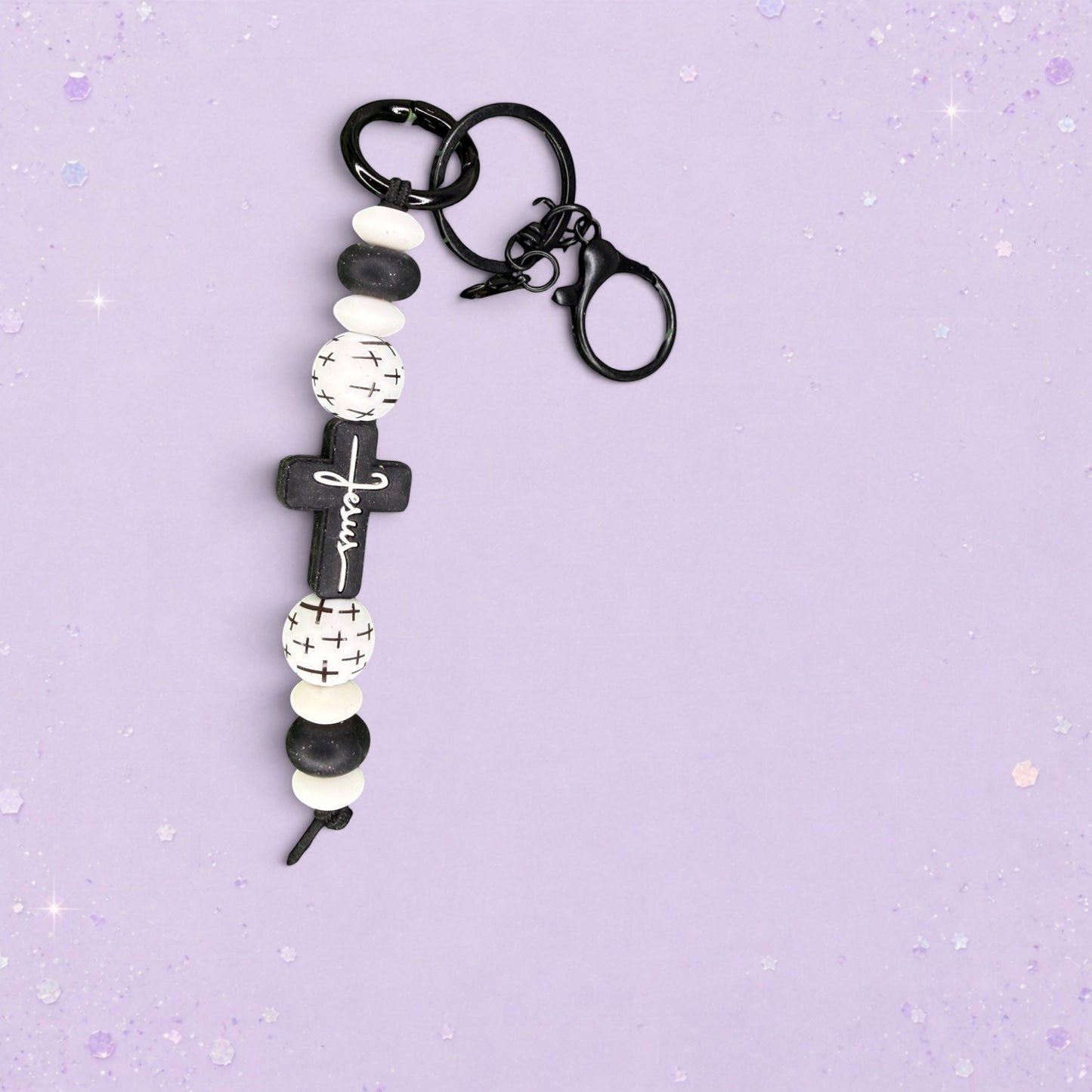 BeFreshie handmade beaded keychain with black cross charm that says "Jesus", black and white beads, and silver hardware.