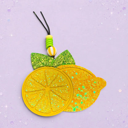 BeFreshie yellow glitter lemon slice and whole lemon car freshie with green bow and beaded hanger.
