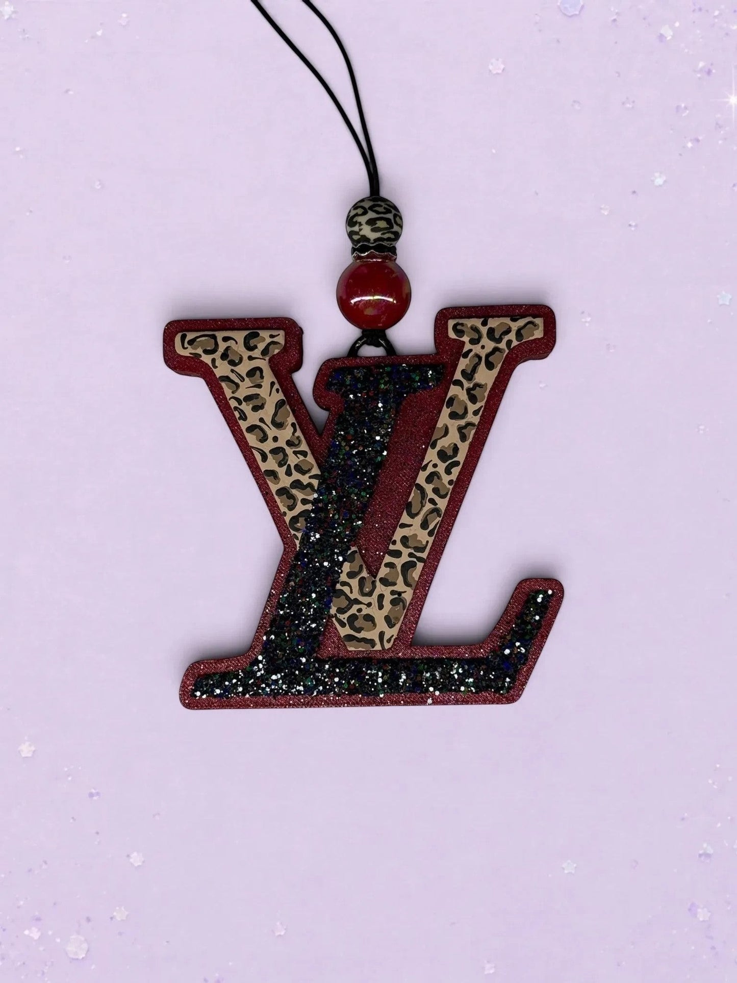 BeFreshie LV car freshie featuring a maroon and black glitter logo with a leopard print accent and decorative bead.