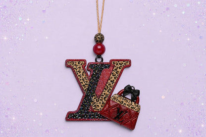 BeFreshie LV freshie car air freshener featuring a glittery leopard print logo and a red handbag charm.