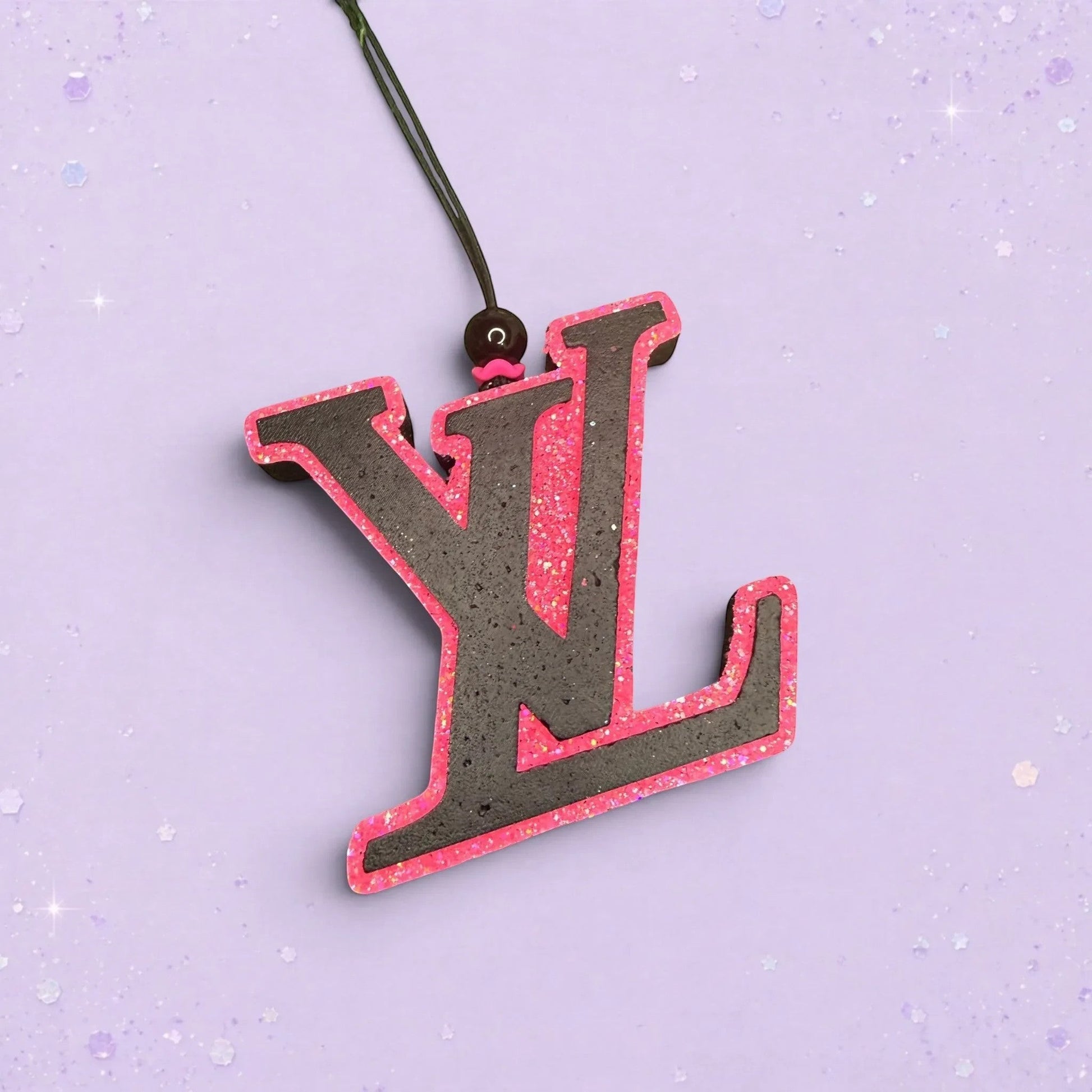 BeFreshie LV logo car air freshener in black with a vibrant pink glitter border on a light purple background