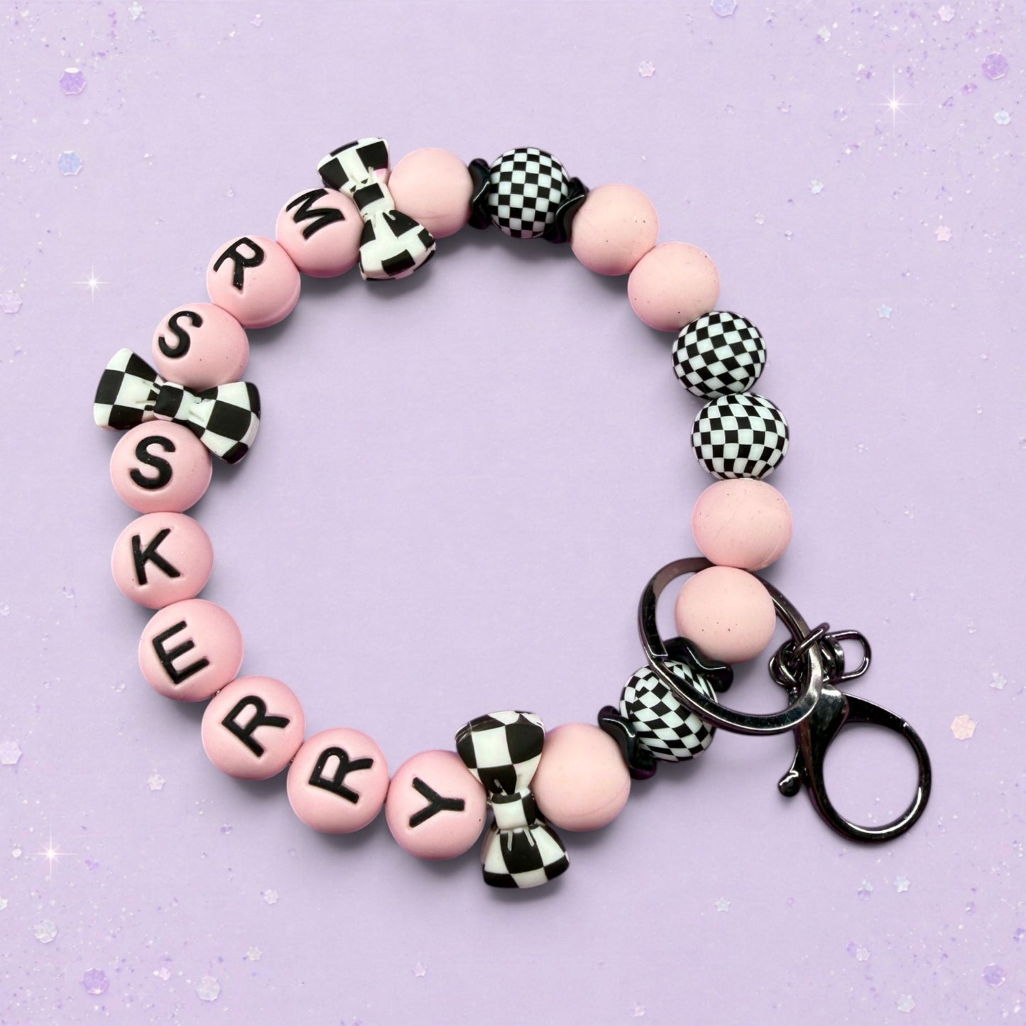 BeFreshie pink beaded keychain with black letters spelling 'SKERRY', checkered bows, and checkered beads.