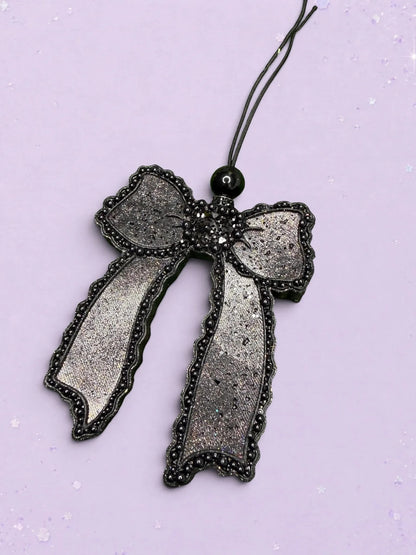 BeFreshie Scallop Bow long tails car freshie in shimmering black with beaded scalloped edges on a lavender background
