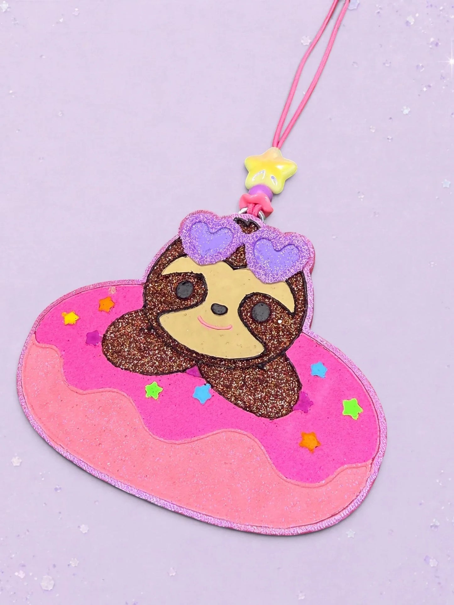 BeFreshie sloth car air freshener featuring a glittery brown sloth wearing purple heart sunglasses on a pink donut float