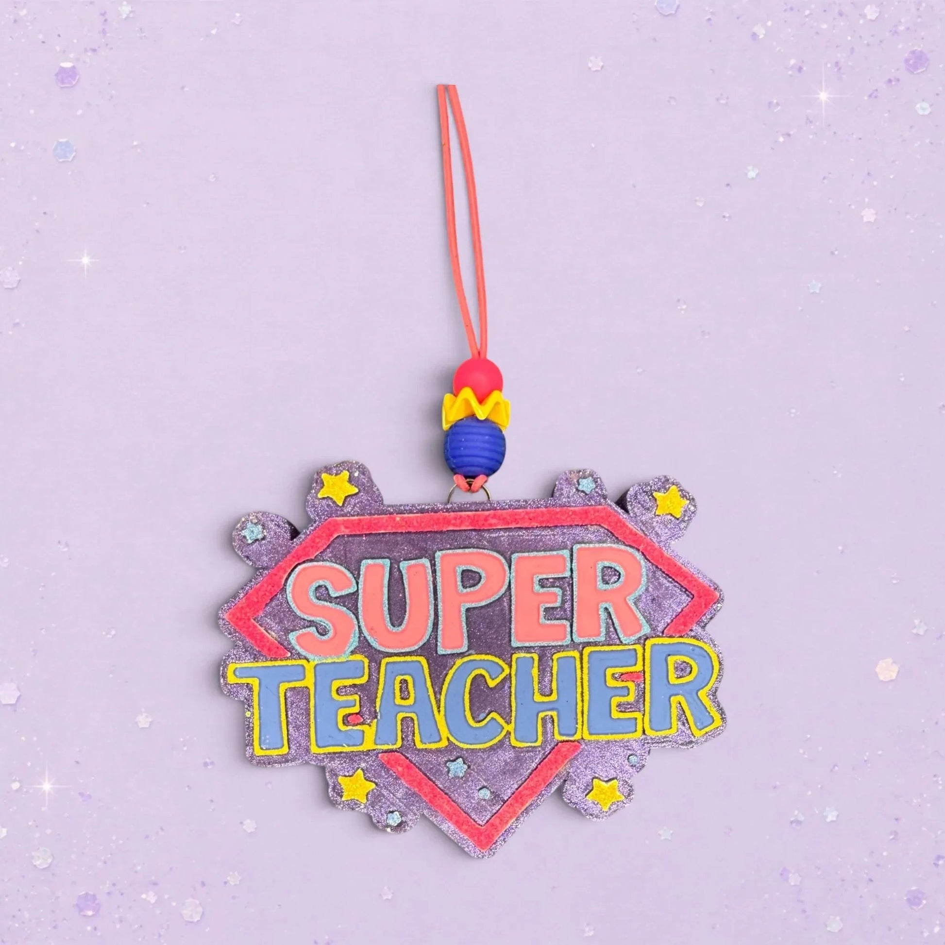 BeFreshie Super Teacher freshie ornament with pink and blue lettering on a purple glitter shield, adorned with yellow stars.