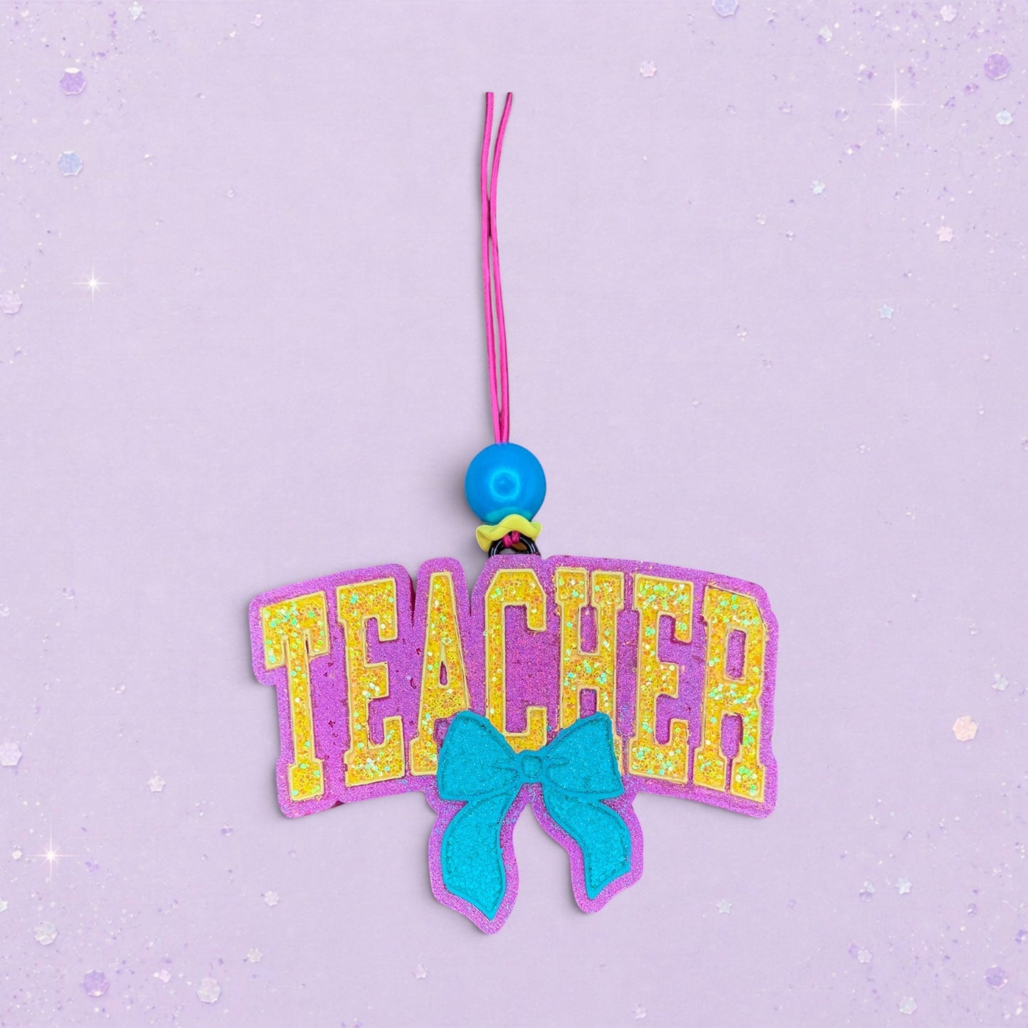 BeFreshie Teacher With Bow freshie, purple with yellow glitter letters and a teal bow.
