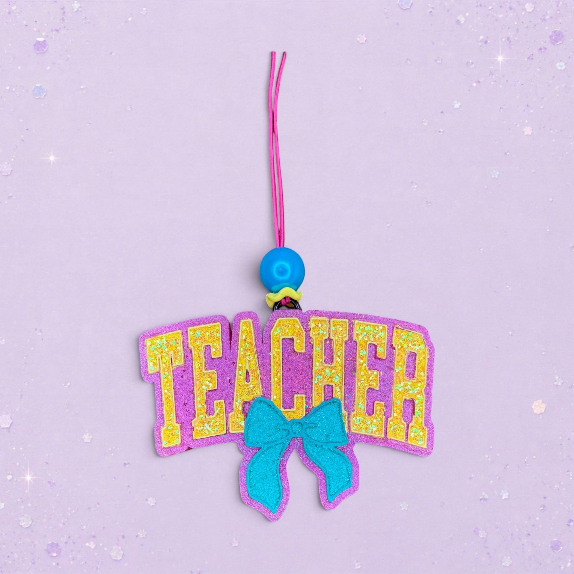 BeFreshie Teacher With Bow freshie, purple with yellow glitter letters and a teal bow.